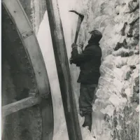 Clay worker trying to free up a frozen water wheel